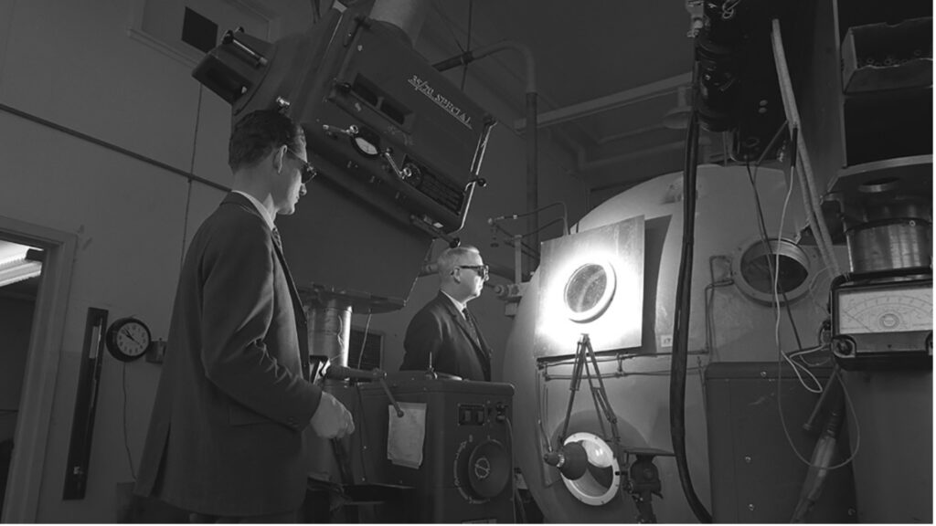 Detail: S. Yool (1923 – 2006), Scientists Pat Holden and Norman Harrison look into the test chamber of the ISIS A Satellite, 1965