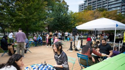 People participate in an outdoor community chess event at The Deck in Clarence Square Park in downtown Toronto.